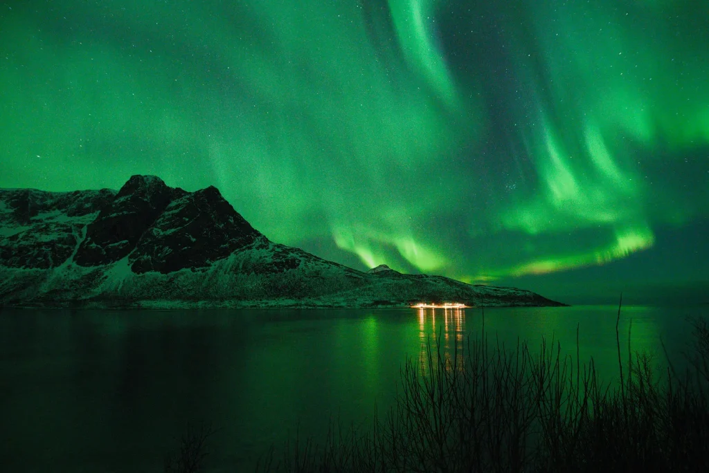 Aurora over a mountain, reflected in the fjord