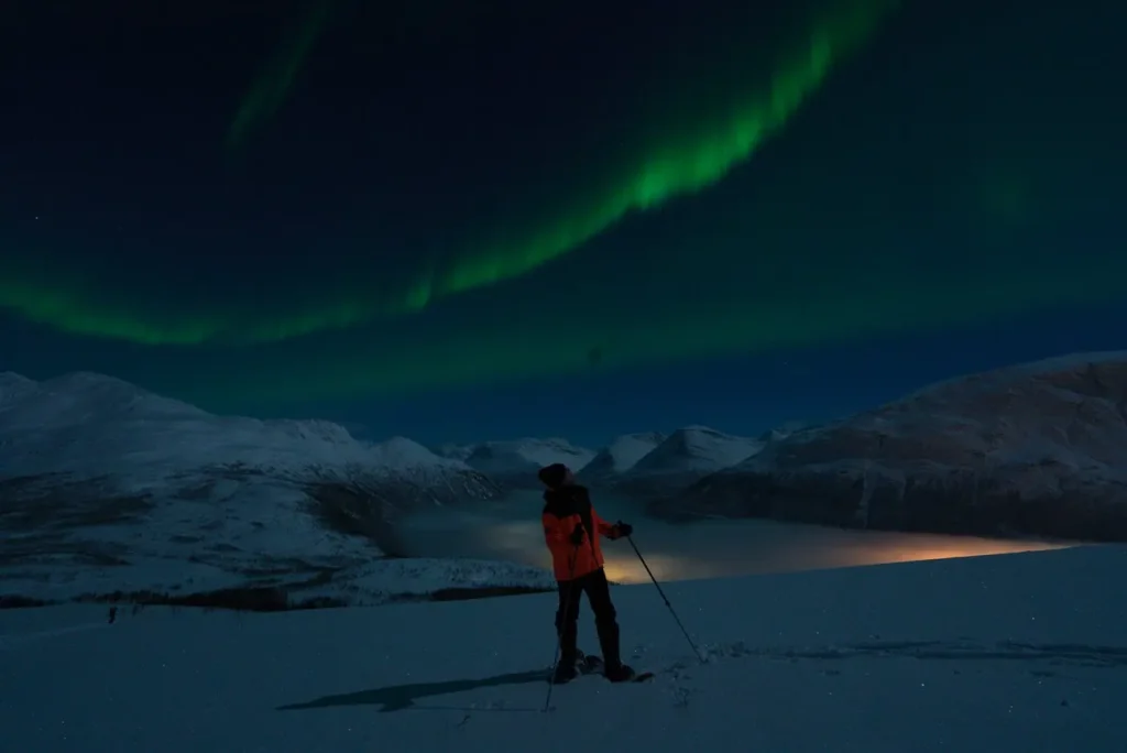 A guest with a headlamp under the northern lights